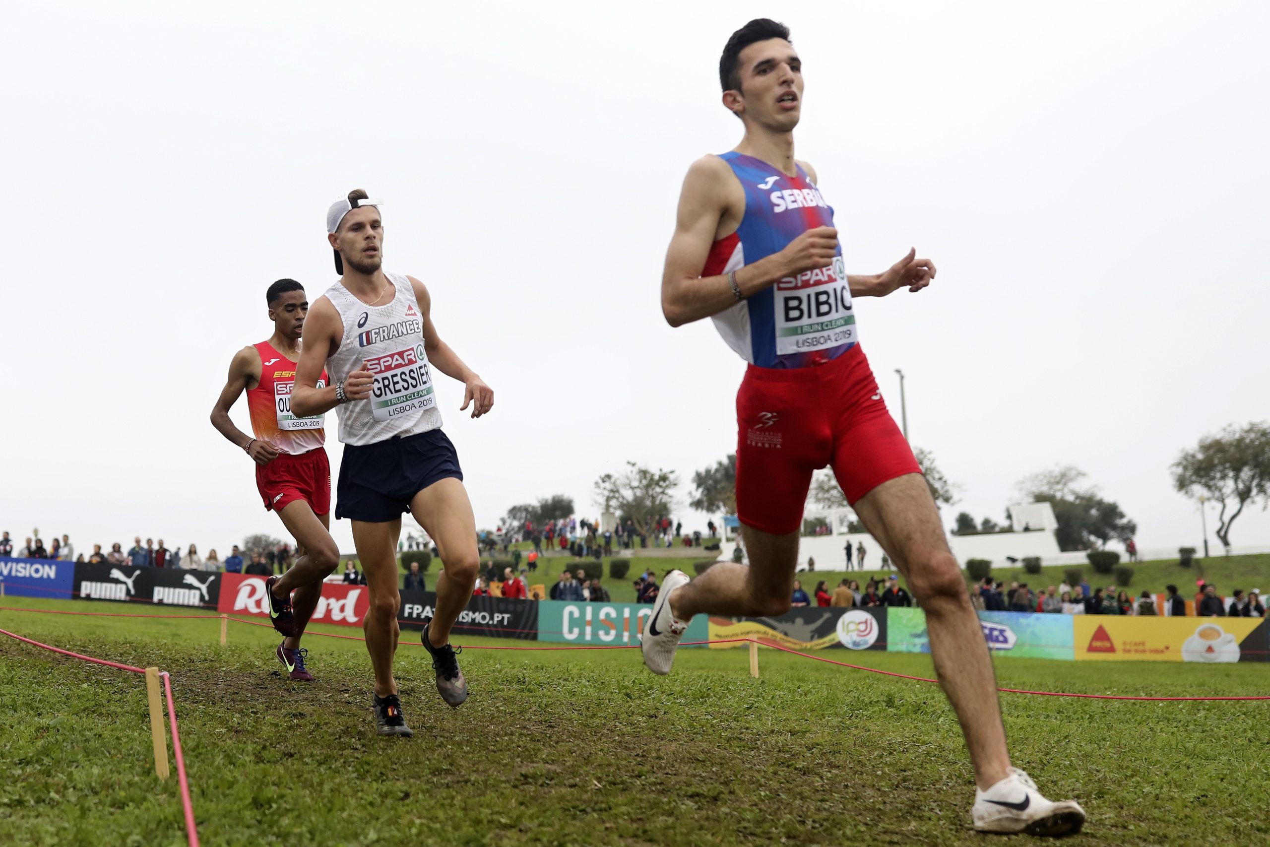 Bronze medalist Abdessamad Oukhelfen of Spain, gold medalist Jimmy Gressier of France and silver medalist Ellen Bibic of Serbia, from left to right, compete in the Under 23 Men's race during the European Cross Country Championships at the Bela Vista park in Lisbon, Sunday, Dec. 8, 2019. (AP Photo/Pedro Rocha)